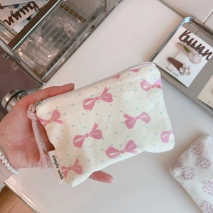 Detail of floral cotton coin purse with pink bow print and branded fabric label