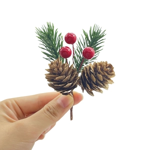 Christmas decorative branch with brown pine cones, red berries, and green pine needles