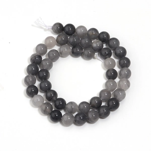Détail de perles de cristal gris semi-transparentes disposées en cercle sur fond blanc