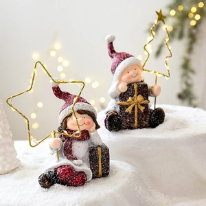 Christmas resin figurines with LED lights featuring boy and girl in festive outfits