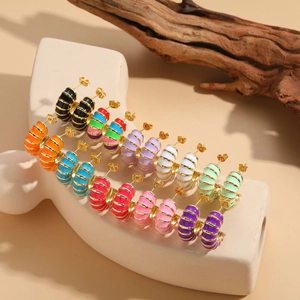 Macro shot of colorful enamel C-shape hoop earrings with ribbed texture on display