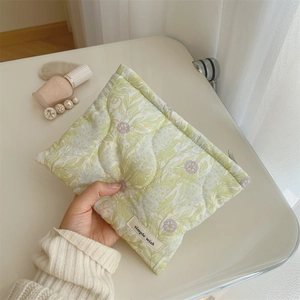 Detailed macro of floral quilted cotton makeup bag with metal zipper and simple wish label