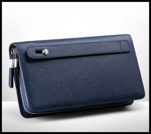 Detail view of navy blue leather clutch with dual zippers and saffiano texture