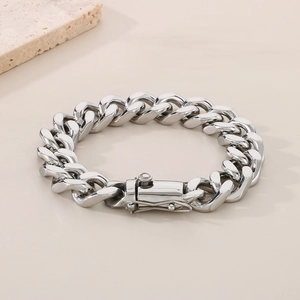 Detailed view of silver Cuban link chain with a secure box clasp on a textured stone base