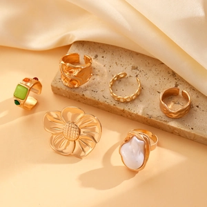 Detailed overhead view of a 6-piece vintage gold floral ring set with pearls and stones
