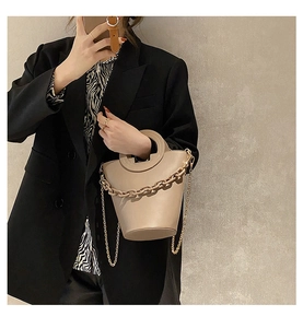 Fashionable beige bucket bag with thick link chain and metallic shoulder strap detail