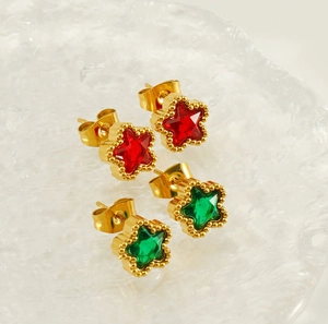 Dettaglio di orecchini a stella placcati oro 18K con gemme rosse e verdi incastonate