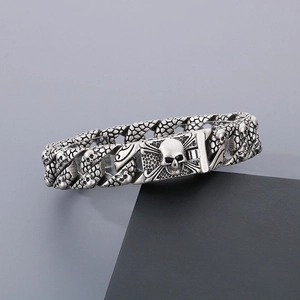 Detailed view of silver skull curb chain bracelet with gothic punk embossed clasp