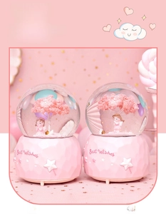 Close-up of pink cherry blossom crystal ball music box with Best Wishes engraving
