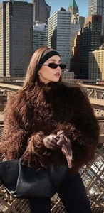 Detailed texture of dark brown faux fur jacket with stylish lapel and matching gloves