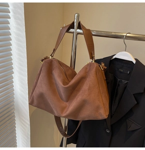 Close-up detail of vintage brown suede baguette bag with textured leather strap and finish