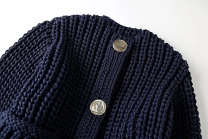 Détail du pull en maille épaisse bleu foncé avec des boutons métalliques argentés