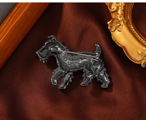 Detailed back view of a vintage gun-metal dog brooch showing the pin mechanism on satin
