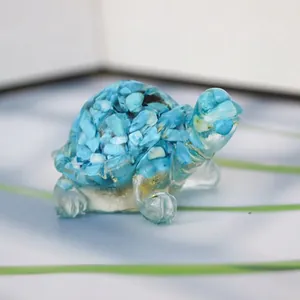 Macro detail of tortoise figurine made with clear resin, blue crystal stones and gold foil