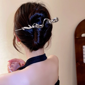 Detail of silver liquid metal butterfly hair clip styled in an elegant hair bun