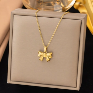 Elegant gold bow pendant necklace made of titanium steel displayed in a jewelry box