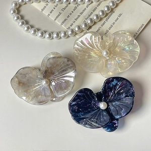 Three acetate orchid hair clips in iridescent white, taupe, and marbled purple with pearls