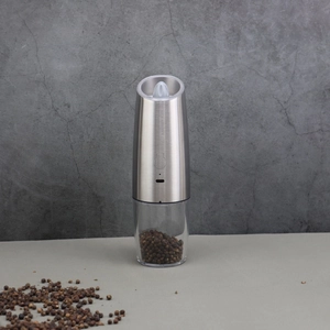 Close-up of electric pepper grinder with stainless steel body and transparent spice container