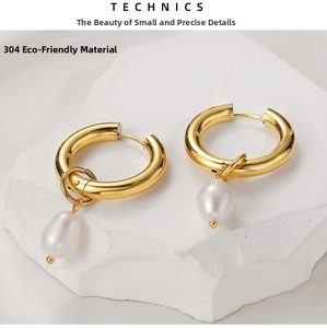 Detail view of gold baroque hoop earrings with white teardrop pearls on 304 stainless steel