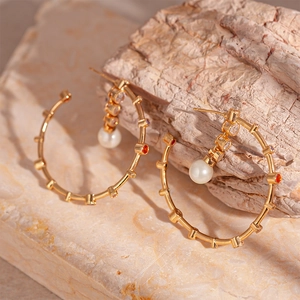 Elegant gold C-shaped hoop earrings with colorful zircons and large white pearls