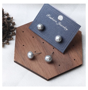 Close-up of S925 sterling silver stamp on gray pearl stud earring with metallic luster