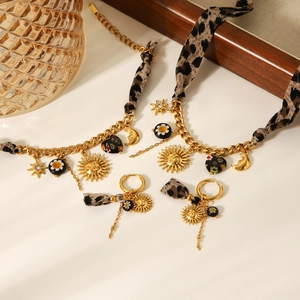 Detail of leopard print fabric and gold sun moon charms on stainless steel jewelry