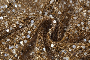 Détail du tissu en maille marron avec paillettes blanches brillantes et texture crochet