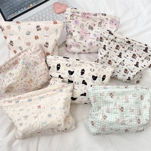 Flat lay of diverse floral and cartoon pattern makeup bags in soft bubble fabric