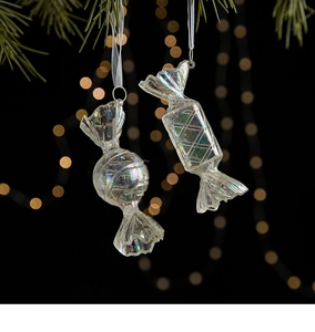 Detailed view of iridescent acrylic candy ornaments with white ribbons on a pine branch