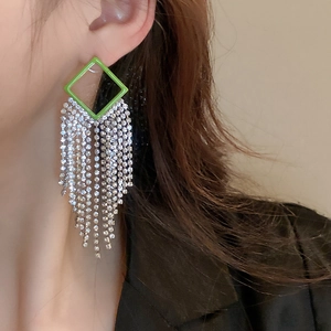 Detailed view of elegant silver earrings with vibrant green diamond-encrusted fringe