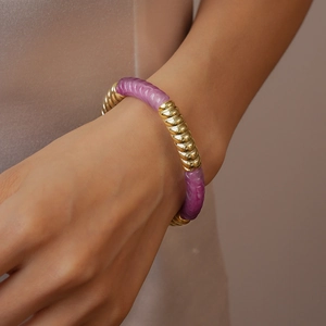 Détail du bracelet en perles acryliques vintage avec spirale dorée sur le poignet