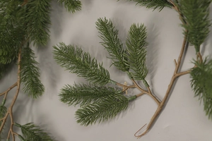 Detailed view of realistic green PE pine needles and brown branch for Christmas decor