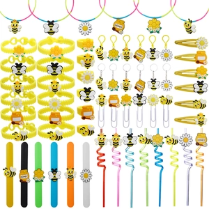 Flat lay of bee-themed party favors including bracelets, keychains and sunflower hair clips
