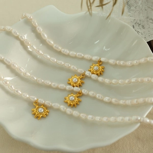 Elegant French style freshwater pearl necklace with gold sunflower pendants in a shell tray