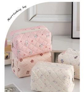 Close-up of three quilted cosmetic bags with cute bear and rabbit patterns on a white table
