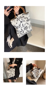 Detail of jacquard canvas bucket bag with bamboo handle and black floral pattern