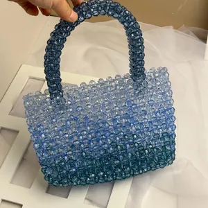 Detailed view of hand-woven gradient blue acrylic beaded handbag with dual top handles