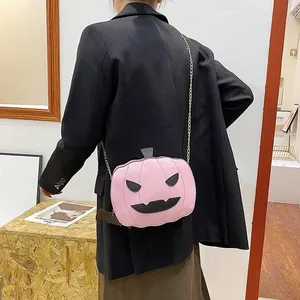 Fashionable pink pumpkin crossbody bag with chain strap styled on a black suit jacket