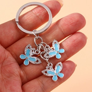 Detail shot of three blue enamel butterflies with small crystals on a silver keychain