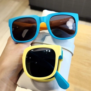 Lunettes soleil pliables enfant montrant monture bleue ouverte et jaune pliée de près