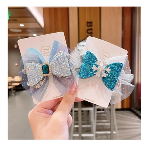 Detail of sequined mesh bow hair clips with blue lace and crystal snowflake accents