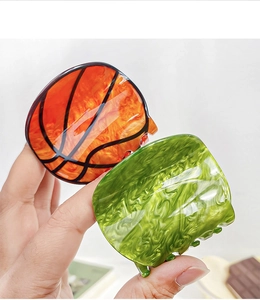 Close-up of basketball pattern and marble green hair claws for athletic styling