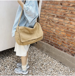 Outdoor street shot of khaki canvas messenger bag showcasing large capacity and casual style