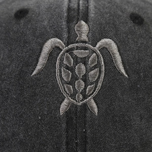Detailed close-up of grey washed cotton baseball cap with 3D turtle embroidery