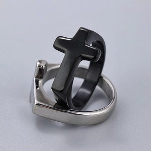 Macro shot showing detail of the black cross ring and silver heart-shaped band together