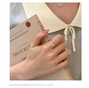 Detail of silver bow jewelry set worn by model in a vintage French artistic style
