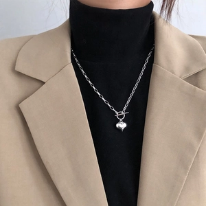 Detail showing silver heart pendant with OT toggle clasp on a stylish necklace chain