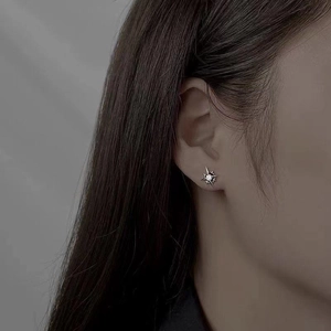 Minimalist S925 silver star stud earring with a sparkling white zircon on a model