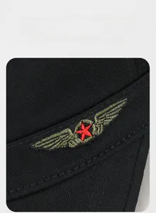 Détail de broderie étoile rouge sur une casquette plate noire en coton pour l'extérieur