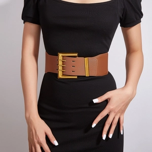 Wide brown faux leather waist belt with large gold buckle on black dress